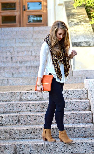 With white shirt, navy blue pants, orange clutch and boots