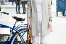 With white shirt, white pants, beige long cardigan, brown high boots and brown bag