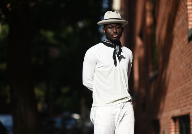 With white shirt, white trousers and hat