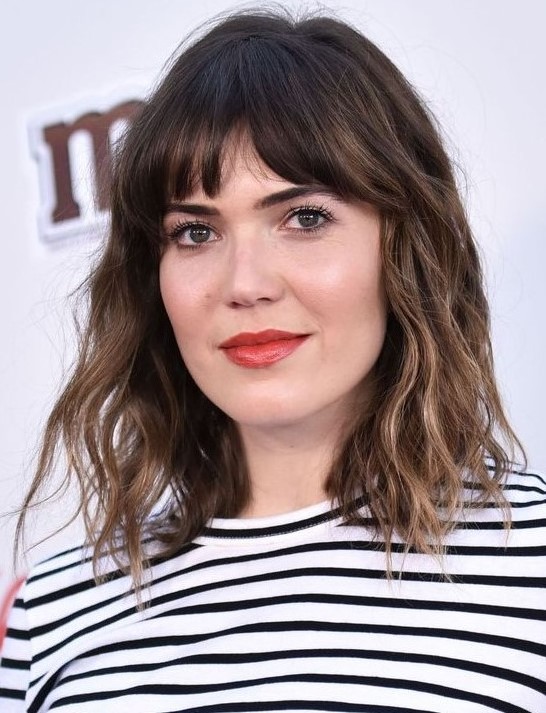 A long dark brunette bob with bronde balayage, bottleneck bangs and waves is a chic and French inspired idea