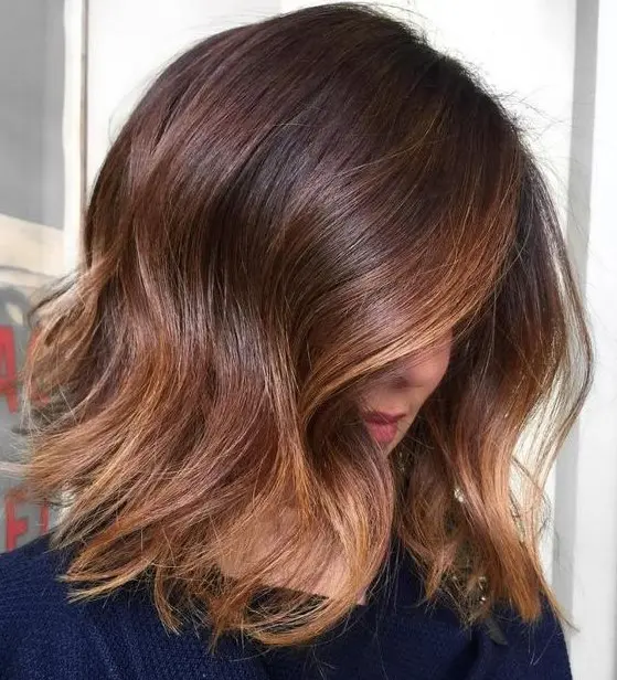 a long layered bob in deep brown, with caramel balayage and ombre and messy waves is a very effortlessly chic idea