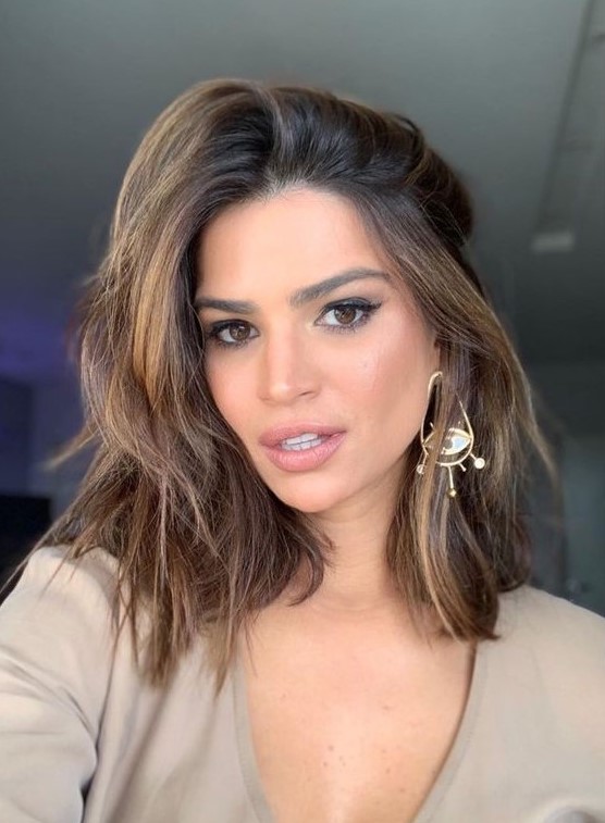 a medium-length brunette haircut with golden blonde highlights and a lot of volume is a stunning idea