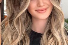 beautiful long hair with warm blonde and bronde balayage, with volume and waves is a stunning and chic idea to rock