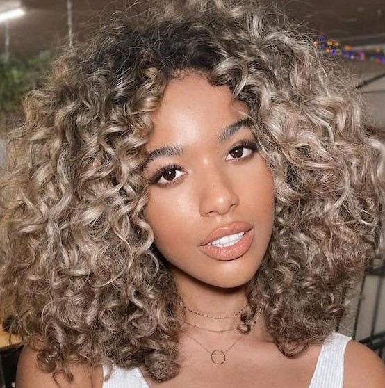 Beige beach blonde hair with chunky highlights, with a few inches of root shadow are throwing us back to sun scorched beach days