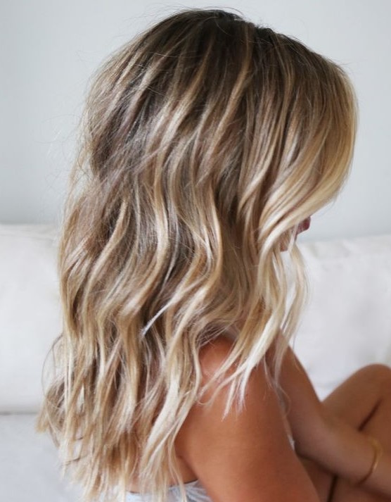 brunette medium length hair with blonde balayage and beach waves is a very chic and relaxed solution