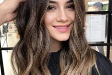 long dark brown hair with bronde balayage and waves is a chic and stylish idea to illuminate the face