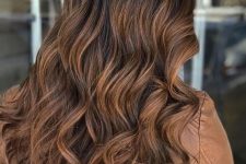 long dark wavy hair with caramel highlights and dark roots is beautiful and chic and looks gorgeous