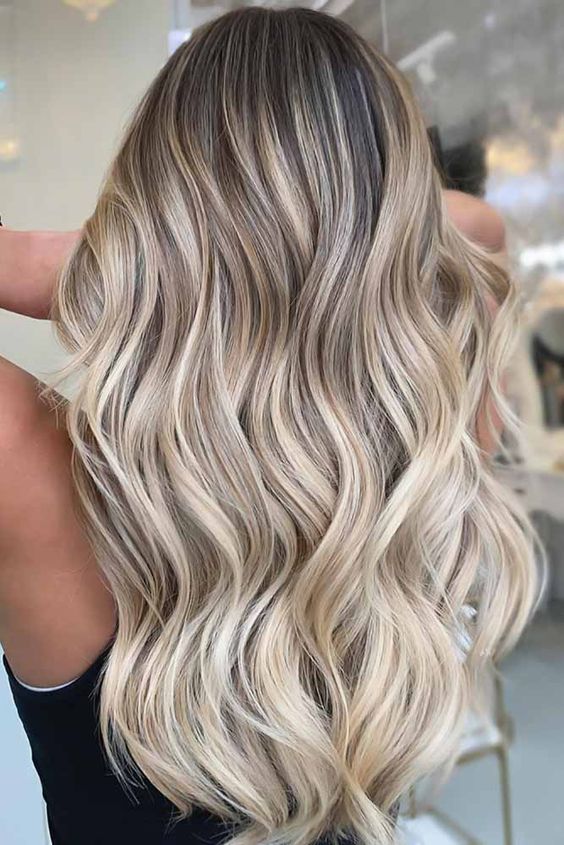 long hair with cold blonde balayage and darker root, with waves and volume is a super catchy and chic idea