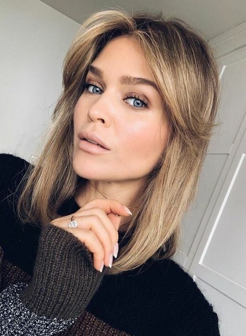 medium hair with honey blonde balayage, curtain bangs and a dark root is a stylish and cool idea