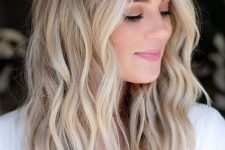 medium-length hair with blonde balayage and waves, a darker root is a chic and cool idea to try right now