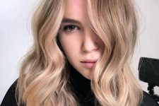 medium-length hair with warm blonde balayage, waves and volume is a stylish and catchy idea, it looks chic and lovely