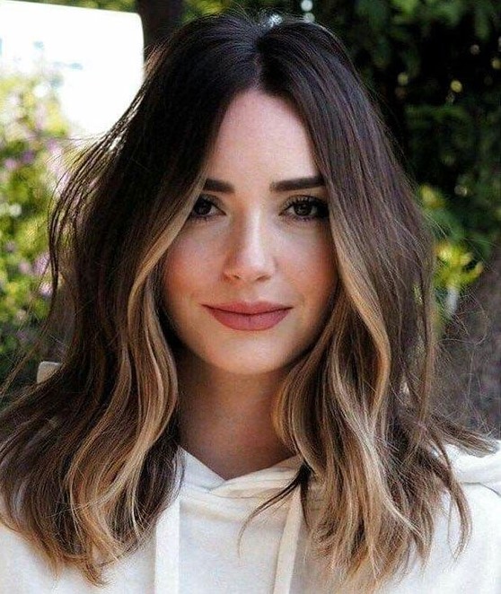 shoulder-length dark brunette hair with golden blonde highlights and some volume and waves looks wow