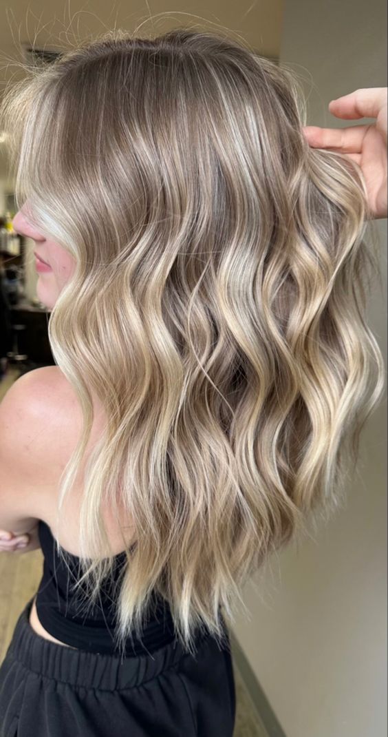 volumetric long hair with lovely blonde balayage and waves is a stunning solution to try right now