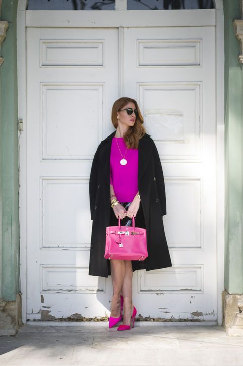 a black knee skirt, a hot pink top and shoes, a pink bag, a black coat