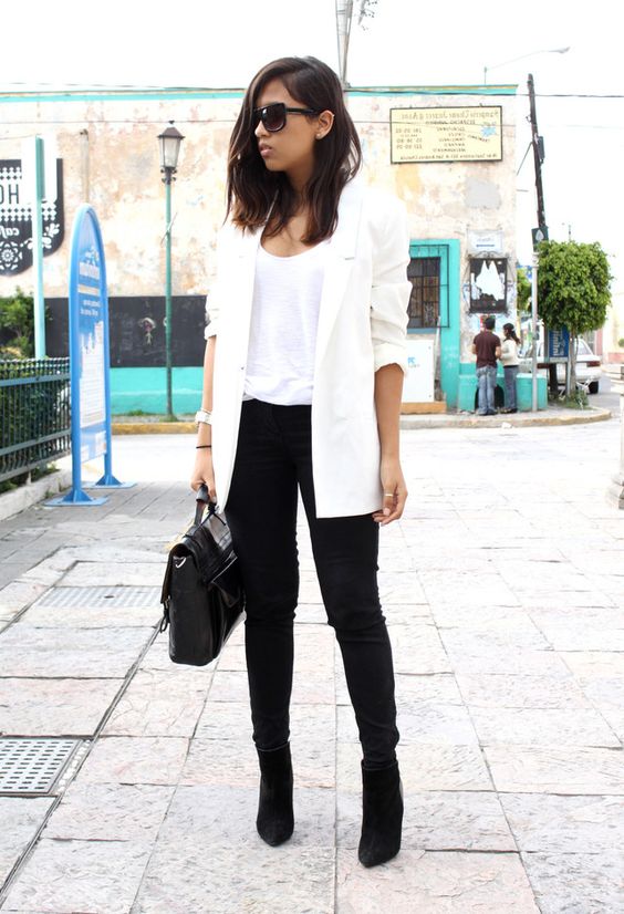 black skinnies, black suede booties, a white top and a long blazer and a black bag