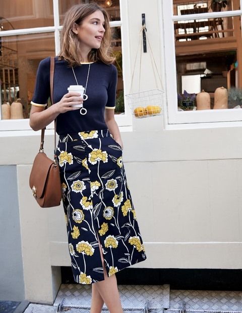a navy floral print midi skirt, a navy top, a brown bag for a modest work look
