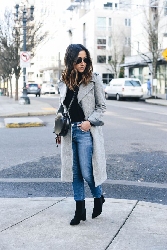 a black top, blue straight jeans, black chelsea boots and a grey coat
