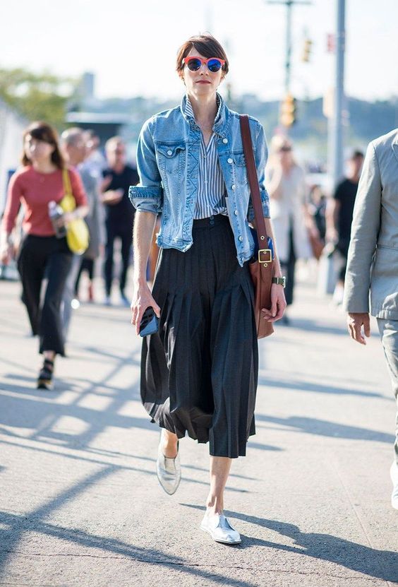 a striped shirt, a blue denim jacket, a black pleated midi and silver Oxford shoes