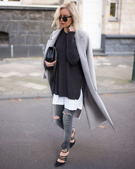 a white tee, a black sweater, a grey coat, grey ripped denim and black strappy shoes