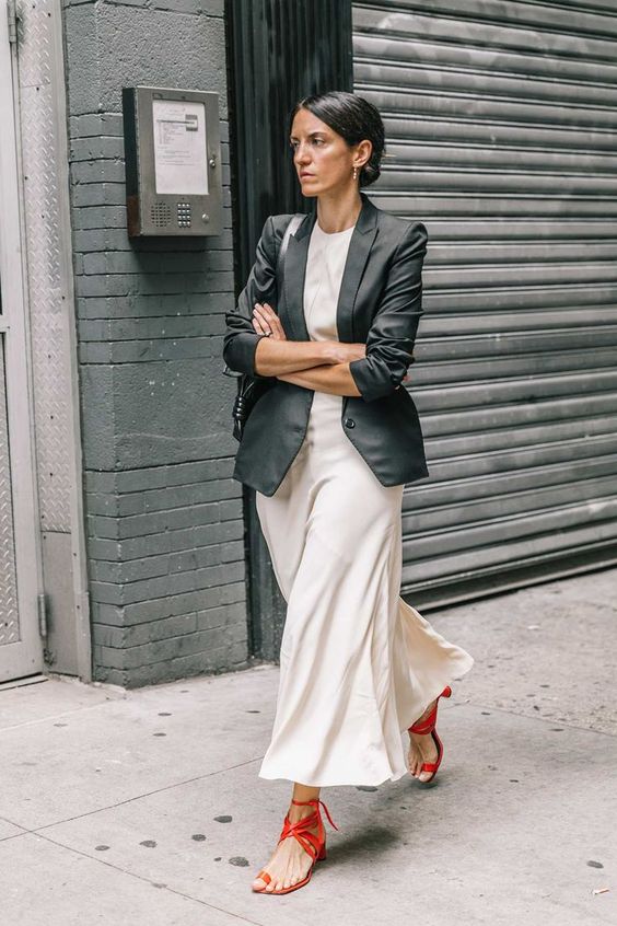 a long black blazer, a neutral midi dress, red strappy sandals for a colorful touch