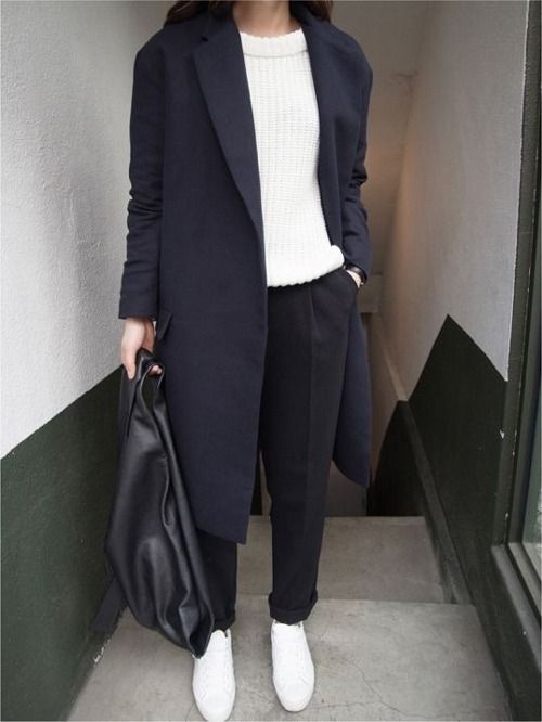 black trousers, a white chunky knit sweater, a black coat and white sneakers