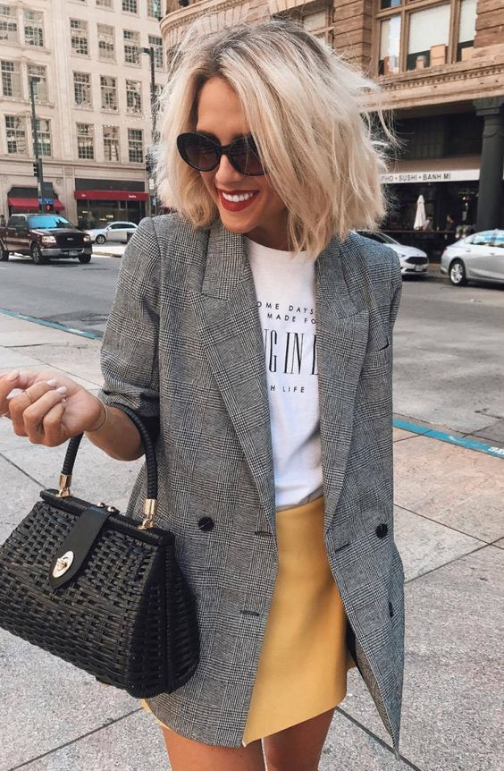 a yellow mini skirt, a printed tee, a checked grey blazer, a black bag for a chic casual look
