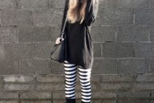 With black long sweater, mid calf boots and black bag