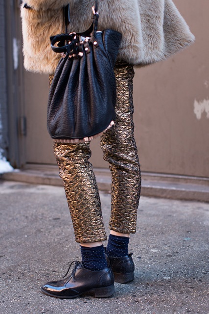 With fur coat, black bag and flat shoes