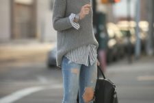With gray sweater, striped shirt, distressed jeans and black bag