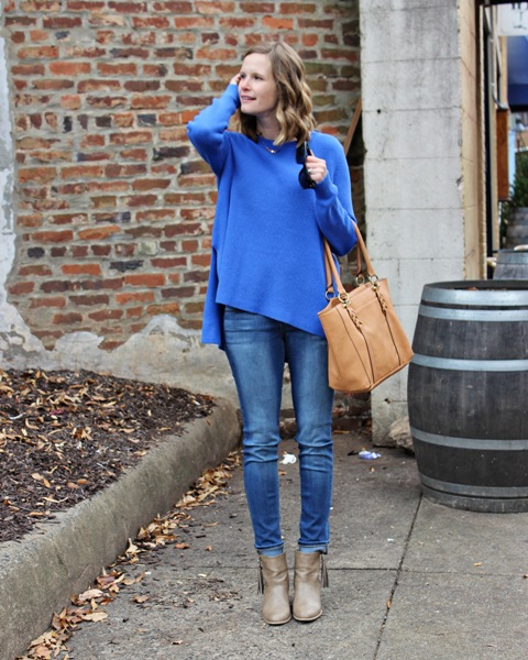 With jeans, gray boots and brown bag