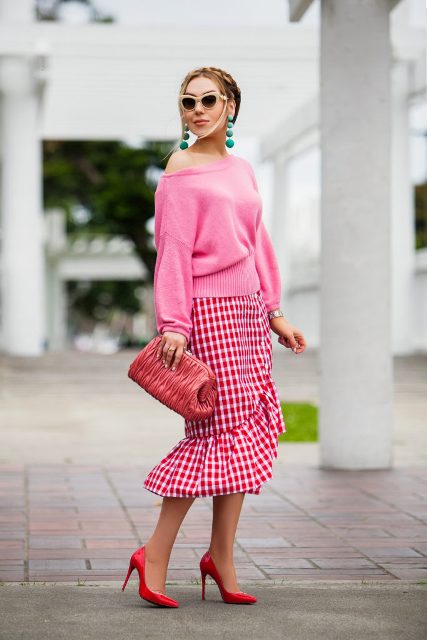 With pink sweater, red pumps and clutch