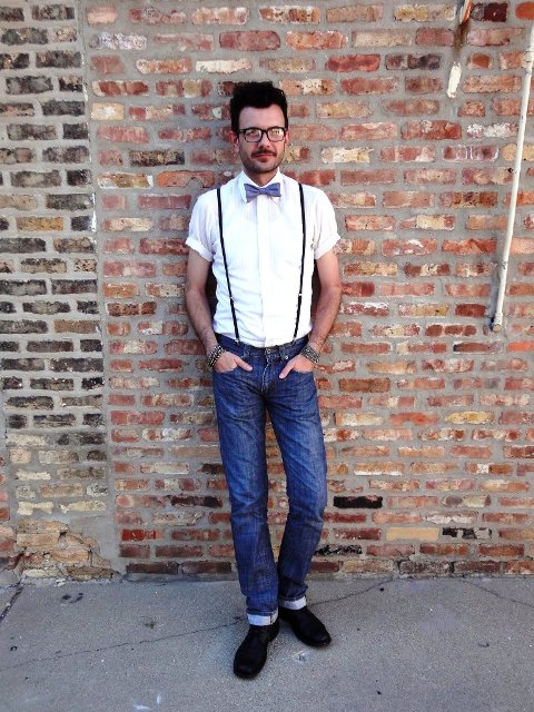 With white shirt, bow tie, cuffed jeans and black boots