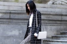 With white shirt, checked coat, jeans, black ankle boots and white bag