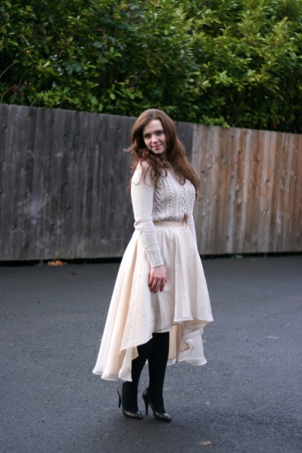 With white sweater, black tights and pumps