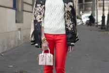 With white sweater, printed bomber jacket, red pants and mini bag