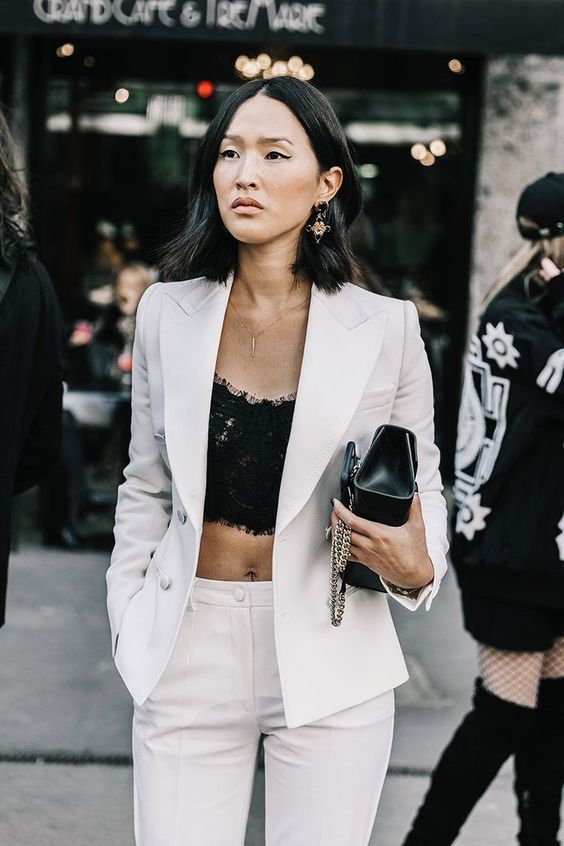 a white pantsuit worn with a black lace crop top is a chic idea for a special occasion