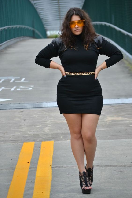 a black sheath mini dress with leather shoulders, a statement belt and black strappy heels
