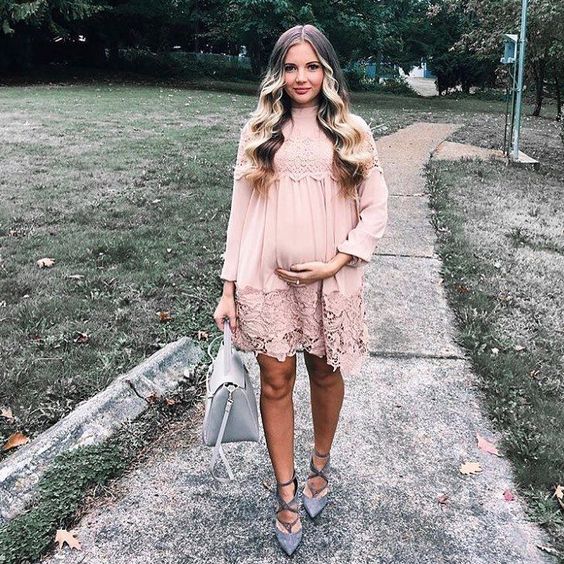 a blush lacey dress with long sleeves, a high neckline, grey suede strappy heels and a grey bag