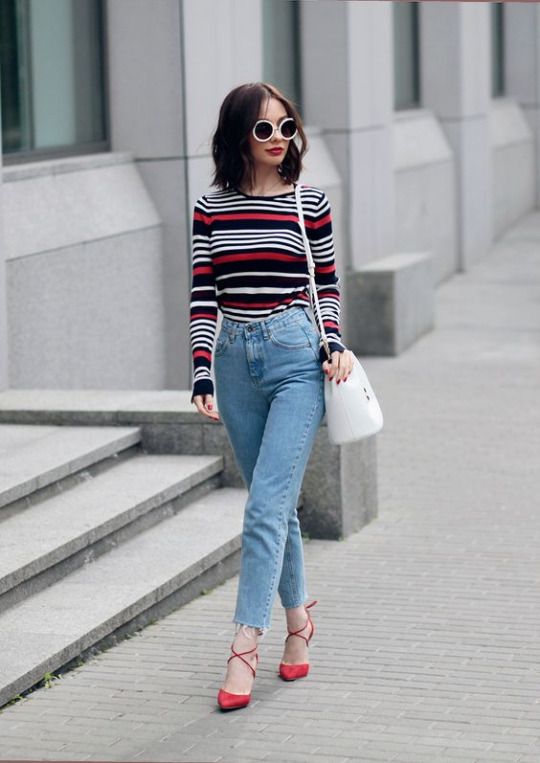 a striped top, blue high waisted raw hem jeans, red strappy shoes for a playful touch