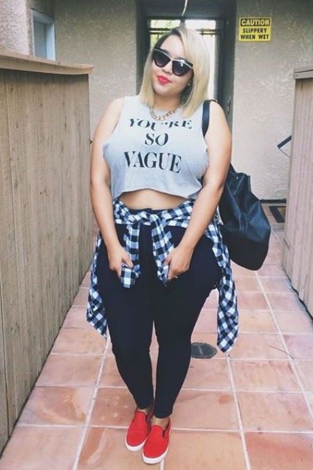 black jeans, a printed crop top, a checked shirt, red slipons and a black bag