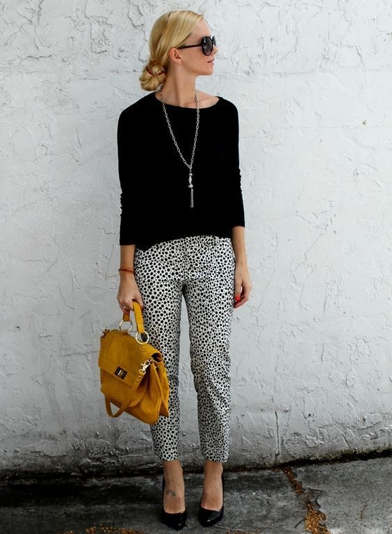 dalmatin printed cropped pants, a black top and heels, a statement necklace and a mustard bag