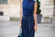 13 navy culottes, a navy wrap sleeveless top, green shoes and a blue bag for a chic look