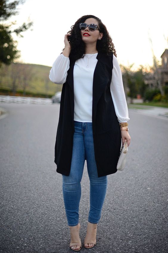 blue skinnies, a white blouse, a long black vest and nude shoes for a chic look