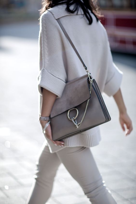 a gorgeous grey leather bag with a large metal ring and a chain plus a leather handle for any occaison