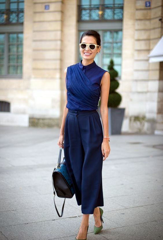 navy culottes, a navy sleeveless blouse with buttons, green heels for an exquisite look
