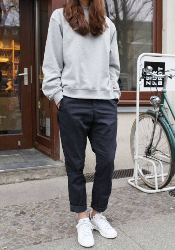 wear cuffed black pants, a grey sweatshirt and white sneakers to work on a casual day