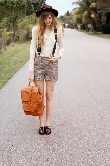With beige shirt, wide brim hat, brown shoes and brown backpack