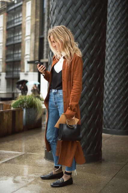 With black top, jeans, flat shoes, black bag and coat