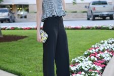 With black wide leg trousers, pink lace up sandals and printed clutch