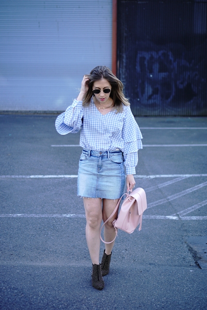 With denim skirt, pink backpack and ankle boots